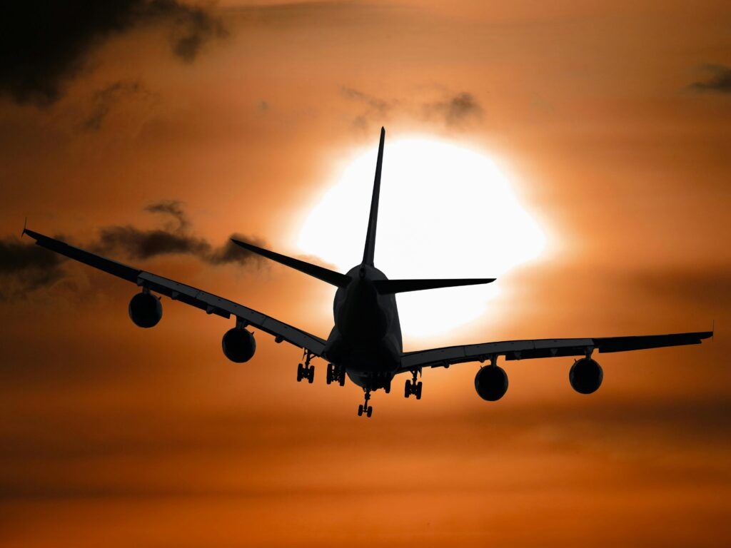 Airplane flying into sunset