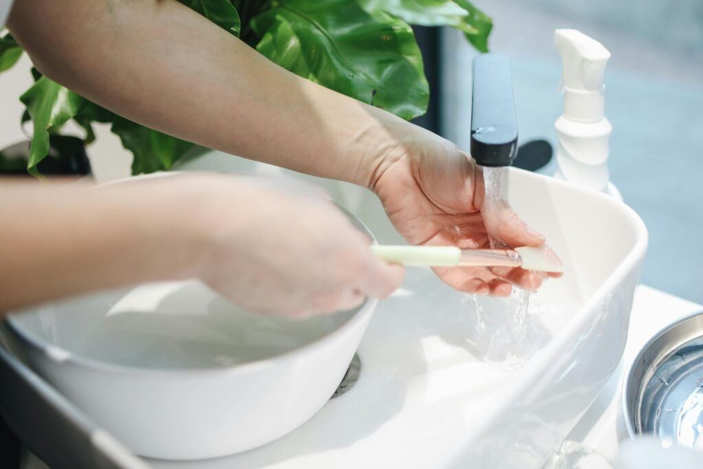 A toothbrush being washed under running water