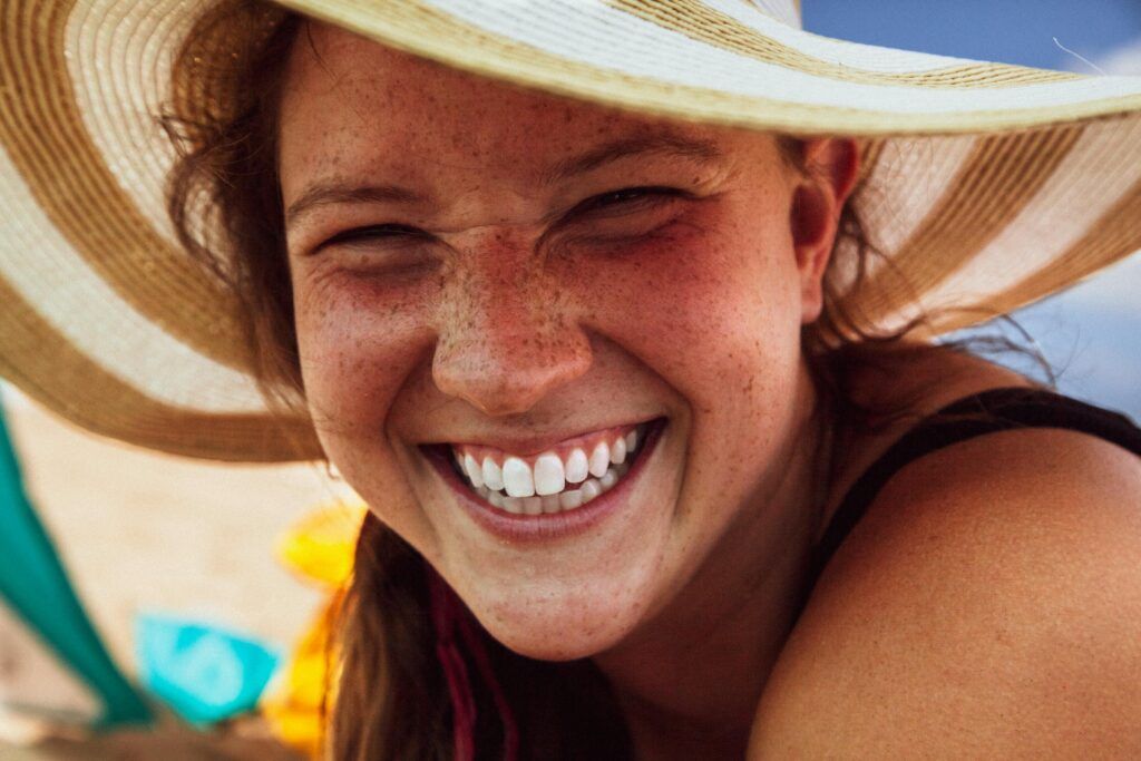 Smiling young lady with a hat.